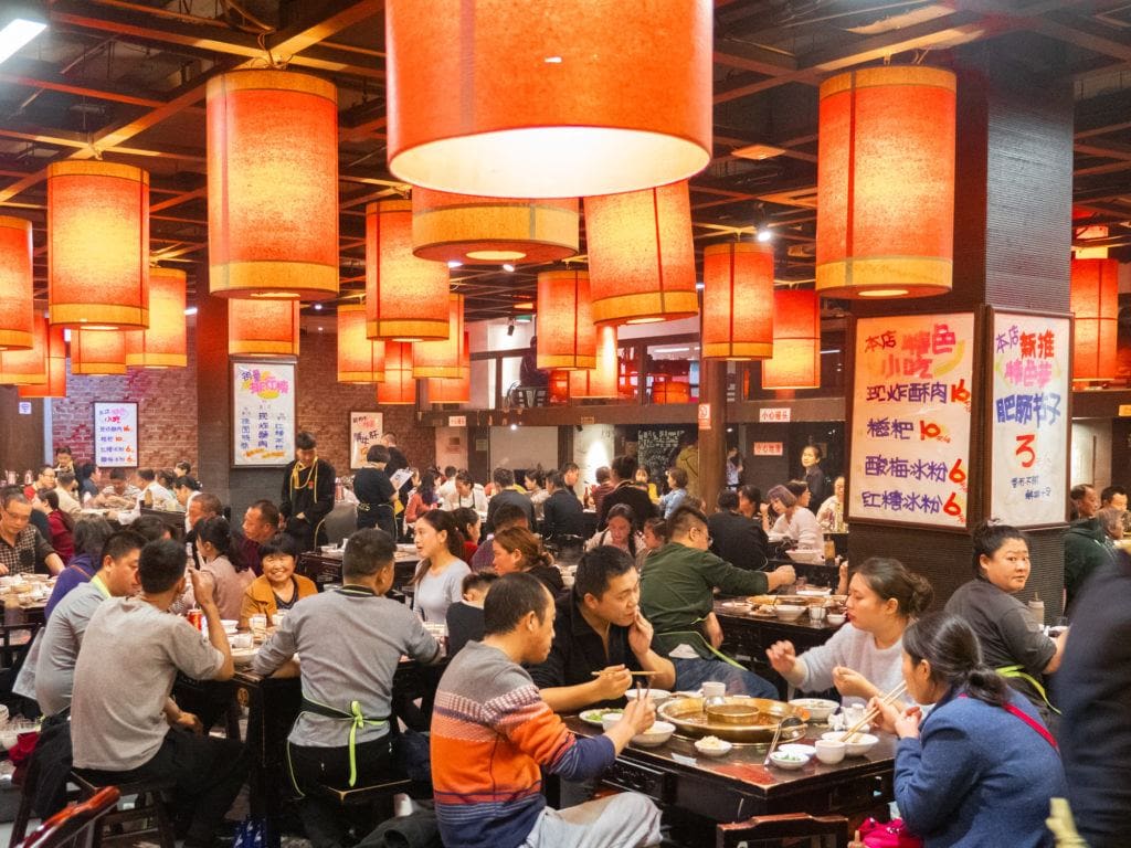 So many full tables of customers eating spicy hot pot
