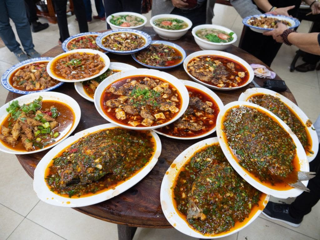 a huge table full of sichuan food in chengdu china